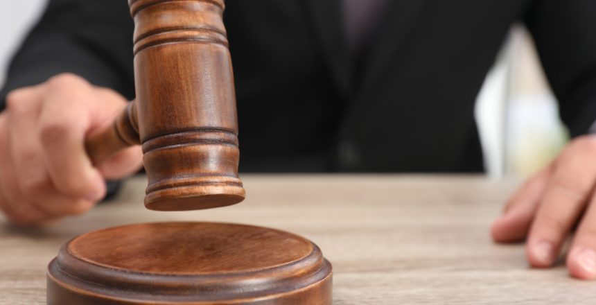 Judge,With,Gavel,At,Wooden,Table,Indoors,,Closeup.,Criminal,Law